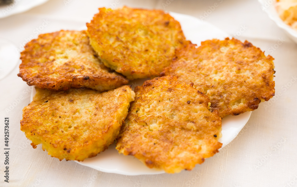 Potato pancakes with sour cream on white plate Potato pancakes with sour cream on white plate