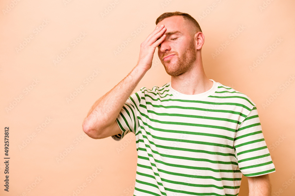 Young caucasian man isolated on beige background laughing happy, carefree, natural emotion. Young caucasian man isolated on beige background laughing happy, carefree, natural emotion.