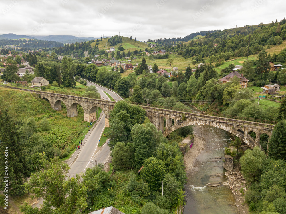 Old railway bridge in the mountains. Ukrainian Carpathians. Aerial drone view. Old railway bridge in the mountains. Ukrainian Carpathians. Aerial drone view.