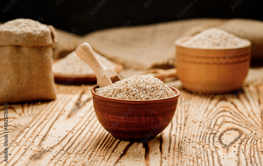 Barley groats in bowls and bags on a wooden background. High quality photo Barley groats in bowls and bags on a wooden background. High quality photo