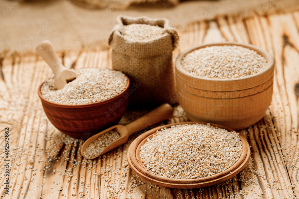 Barley groats in bowls and bags on a wooden background. High quality photo Barley groats in bowls and bags on a wooden background. High quality photo