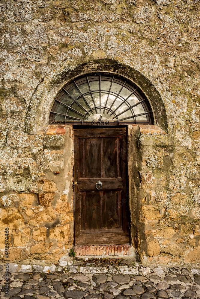 Old wooden locked door of a stone house in Italy