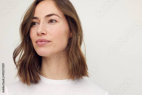Fotografie Beautiful naturally brunette woman, smiling and looking to the left