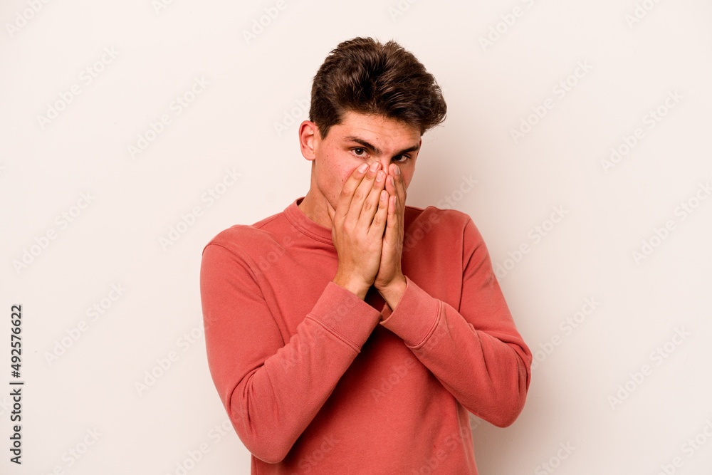 Young caucasian man isolated on white background shocked, covering mouth with hands, anxious to discover something new. Young caucasian man isolated on white background shocked, covering mouth with hands, anxious to discover something new.