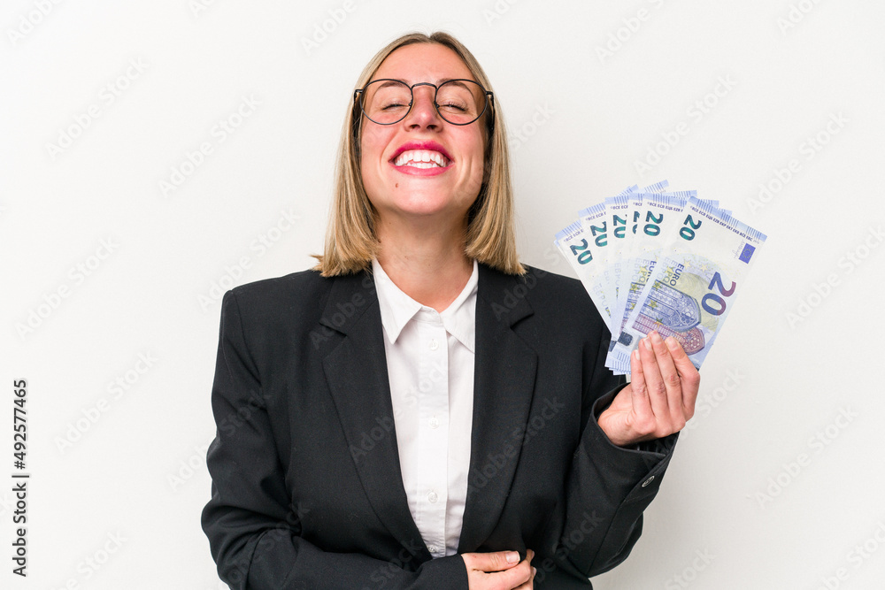 Young business caucasian woman holding banknotes isolated on white background laughing and having fun. Young business caucasian woman holding banknotes isolated on white background laughing and having fun.