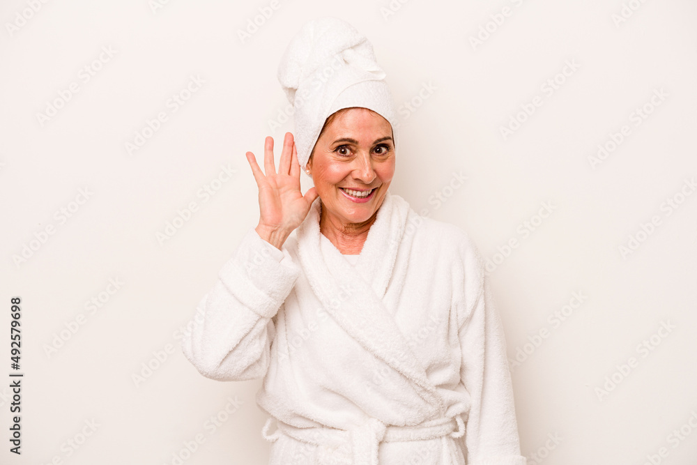 Middle age caucasian woman wearing a bathrobe isolated on white background trying to listening a gossip. Middle age caucasian woman wearing a bathrobe isolated on white background trying to listening a gossip.