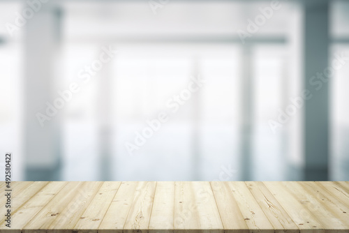 Blank wooden desktop with empty space on modern office interior with large window background, closeup, mock up © Pixels Hunter