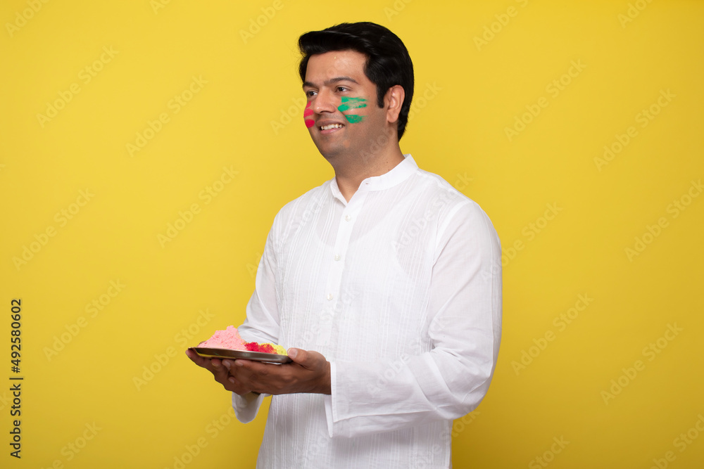 Young man celebrating holi 