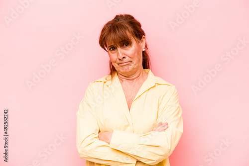 Middle age caucasian woman isolated on pink background unhappy looking in camera with sarcastic expression. photo