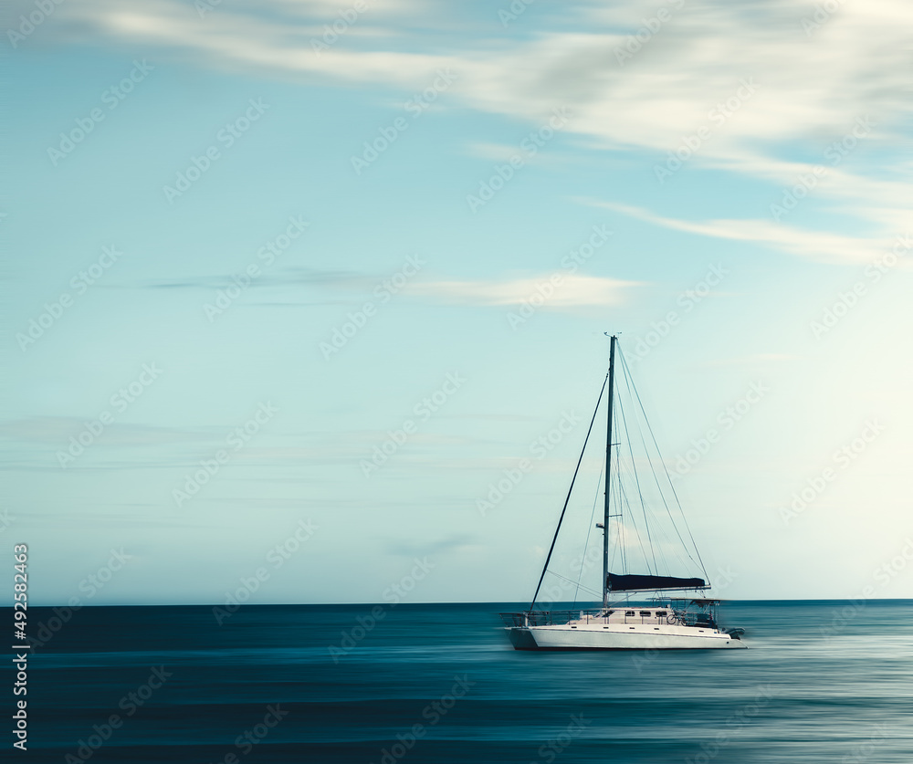 Fototapeta premium Beautiful minimalist panning shot of a boat in the ocean