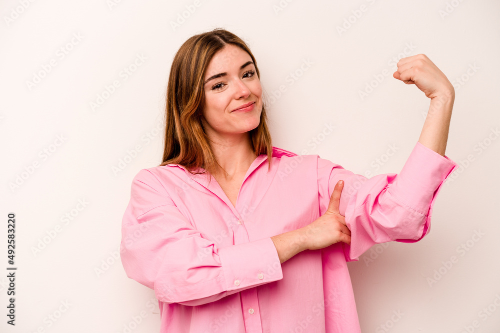 Young caucasian woman isolated on white background showing strength gesture with arms, symbol of feminine power Young caucasian woman isolated on white background showing strength gesture with arms, symbol of feminine power