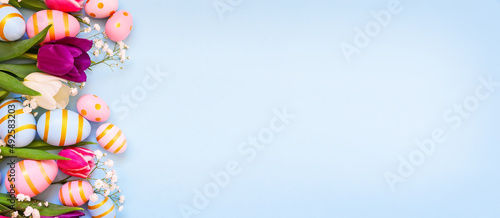 Photography Easter holiday background with colorful easter eggs and tulip flowers on blue background