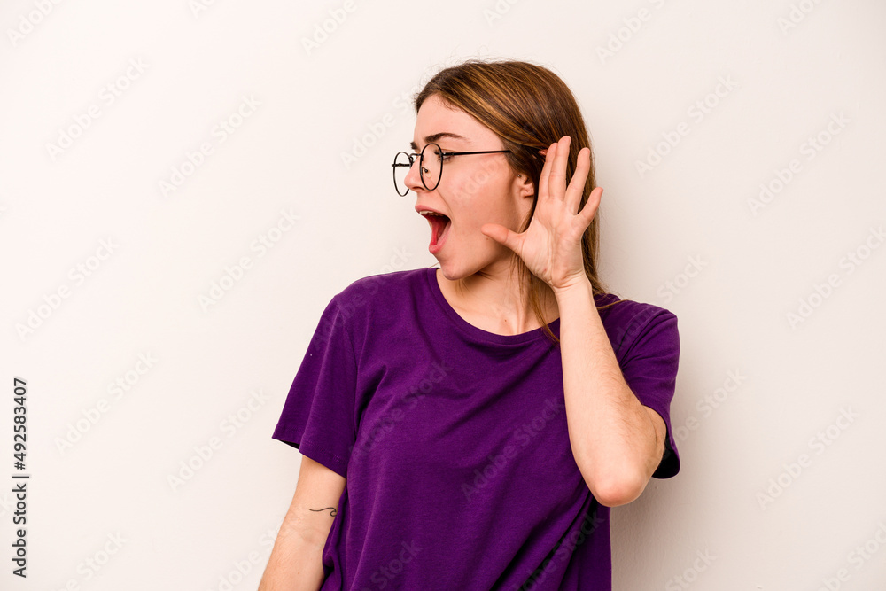 Young caucasian woman isolated on white background trying to listening a gossip. Young caucasian woman isolated on white background trying to listening a gossip.