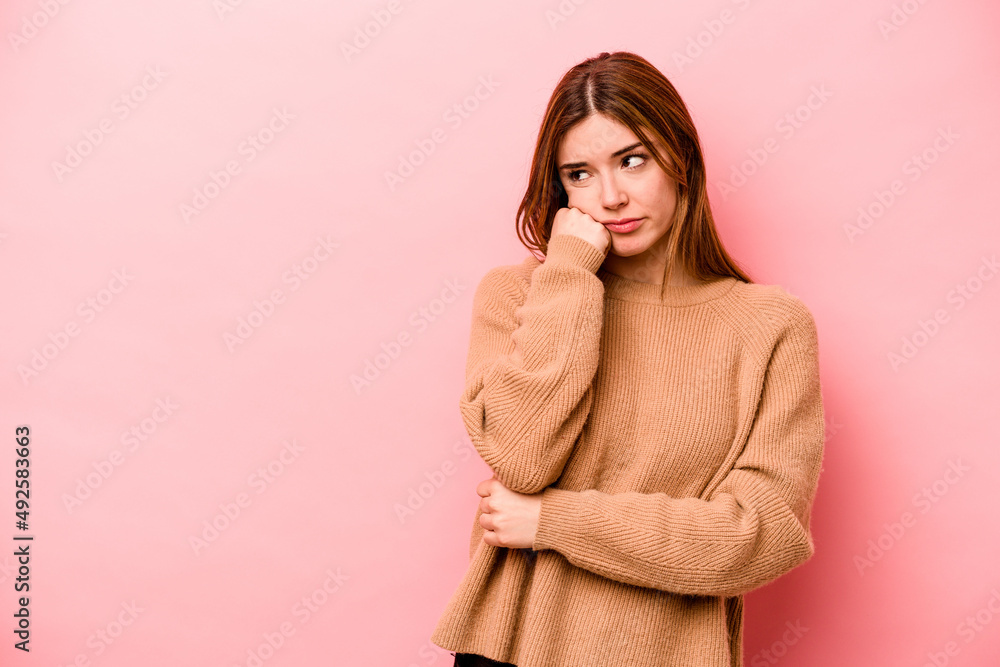 Young caucasian woman isolated on pink background who feels sad and pensive, looking at copy space. Young caucasian woman isolated on pink background who feels sad and pensive, looking at copy space.