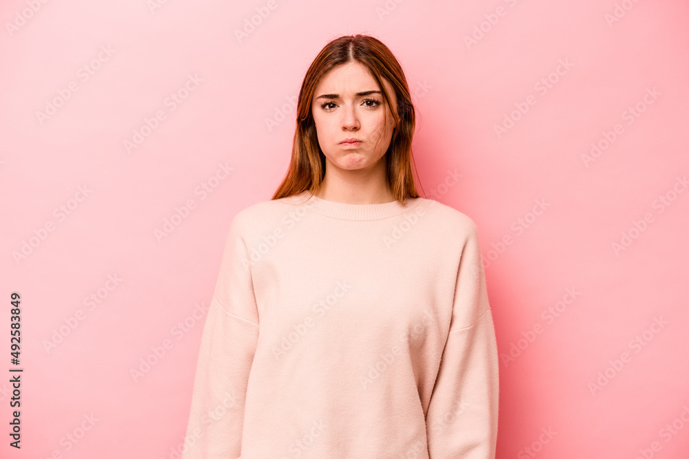 Young caucasian woman isolated on pink background blows cheeks, has tired expression. Facial expression concept. Young caucasian woman isolated on pink background blows cheeks, has tired expression. Facial expression concept.