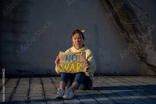 Ukrainian woman with a flag on the cheek and no war sign 