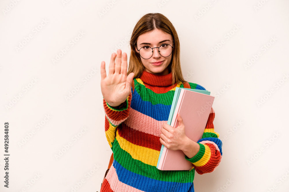 Young student caucasian woman isolated on white background standing with outstretched hand showing stop sign, preventing you. Young student caucasian woman isolated on white background standing with outstretched hand showing stop sign, preventing you.