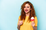 Young ginger woman holding an ice cream isolated on blue background smiling and raising thumb up