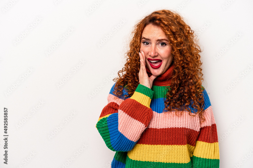 Young ginger caucasian woman isolated on white background shouts loud, keeps eyes opened and hands tense. Young ginger caucasian woman isolated on white background shouts loud, keeps eyes opened and hands tense.
