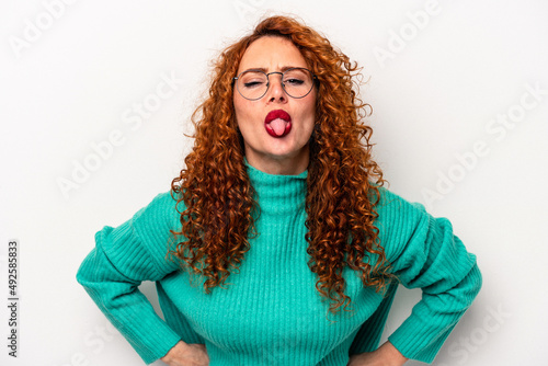 Young ginger caucasian woman isolated on white background funny and friendly sticking out tongue.