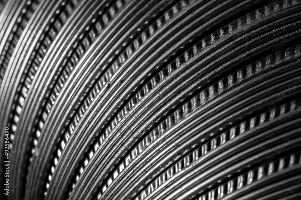 Fototapeta premium The texture of the metal corrugated ventilation pipe. Metal corrugation texture. Ventilation pipe. Embossed metal. Iron. Air conditioning duct. Intake hood air duct. Black and white photo
