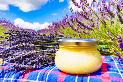 Jar with honey and lavender flowers.