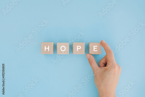 Hope word concept on Wooden blocks with human hand