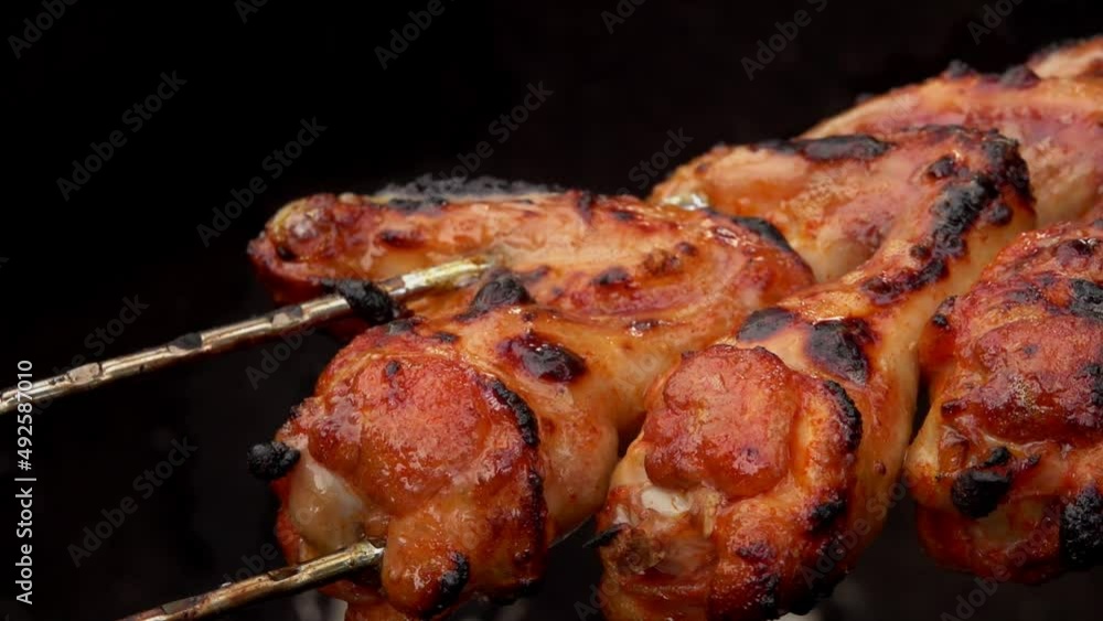 Super close-up of chicken wings on the skewers flipped above the open fire Super close-up of chicken wings on the skewers flipped above the open fire
