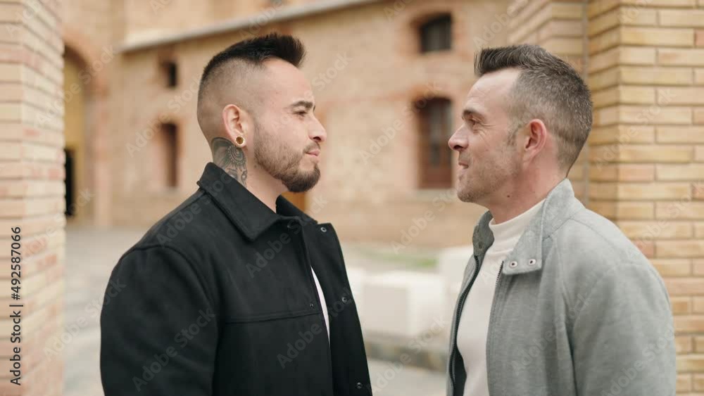 Young couple standing together kissing at street