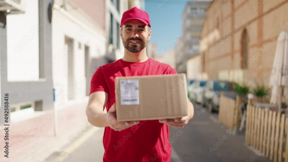 Young hispanic man deliveryman holding package at street Young hispanic man deliveryman holding package at street