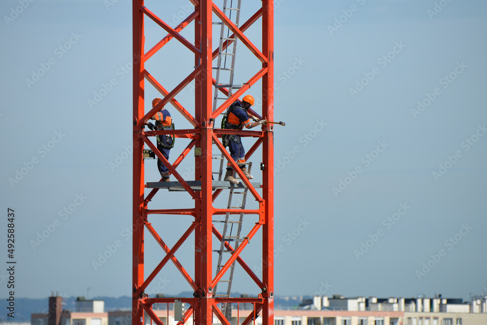 Ouvriers travaillant à la construction d'une grue Ouvriers travaillant à la construction d'une grue