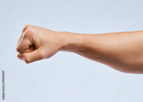 I ought to punch you in the throat. Shot of an unrecognizable man holding his fist up against a white background.