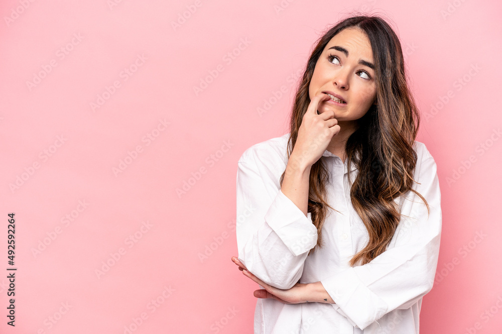 Young caucasian woman isolated on pink background looking sideways with doubtful and skeptical expression. Young caucasian woman isolated on pink background looking sideways with doubtful and skeptical expression.