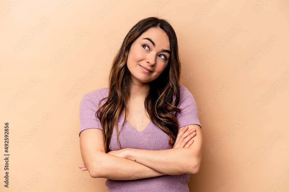 Obraz premium Young caucasian woman isolated on beige background dreaming of achieving goals and purposes