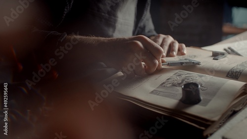 Wallpaper Mural A close-up of the hands of a male jeweler measuring the size of the future product. A book on creating jewelry Torontodigital.ca