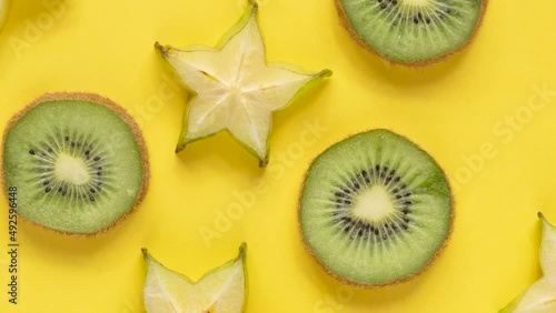 Starfuit and kiwi slices over yellow background photo