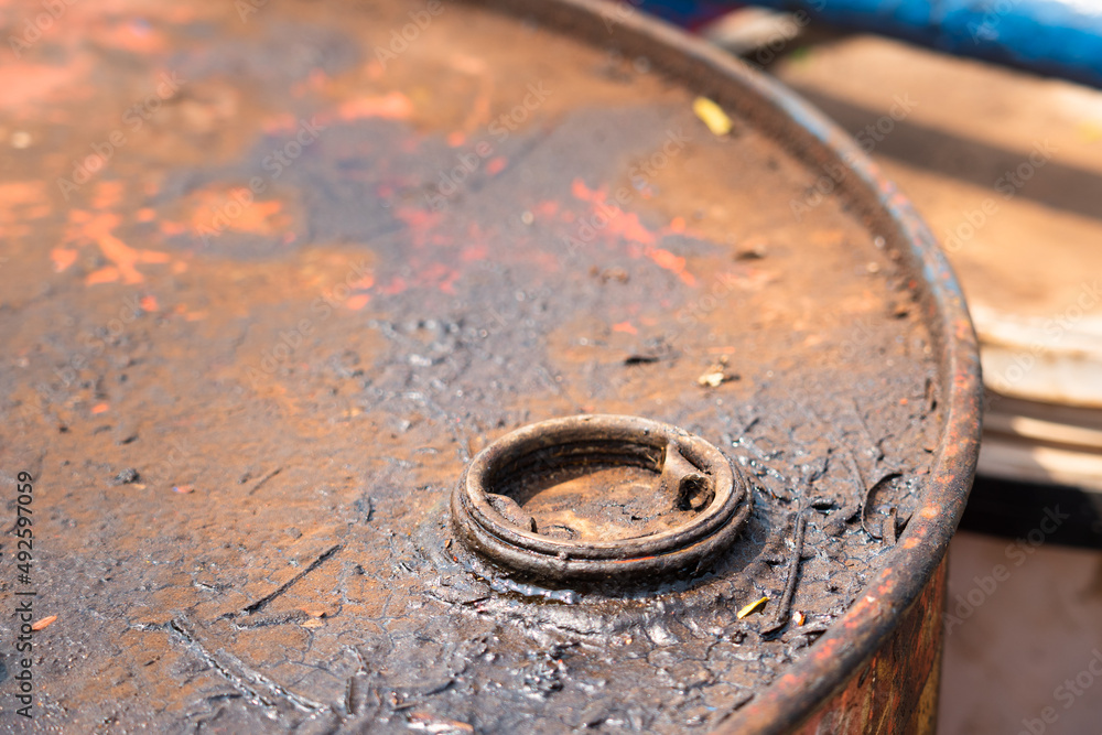 Close-up at dirty metal cap of rusty barrel which is used to store chemical or lubricant oil. Industrial and equipment object photo.