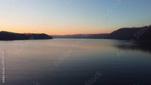 Aerial dron view of lake, water and silhouette of trees during sunset. Evening nature, beautiful landscape. FullHD footage