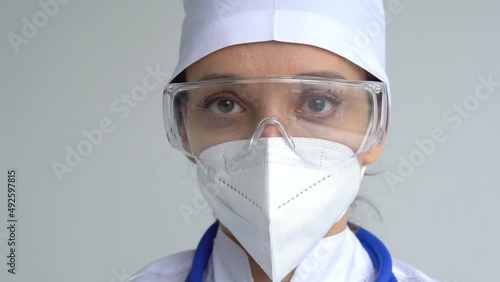 Female doctor is putting off protective blue gloves isolated on white background after some medical manipulations, vaccination.