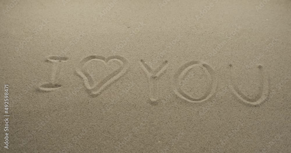 Inscriptions on the sand I LOVE YOU. Slider shot. Close-up
