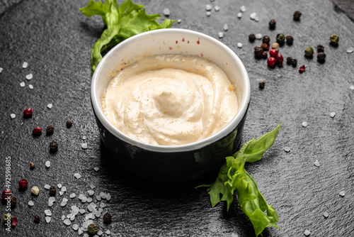 Bowl with garlic sauce on dark background. Food recipe background. Close up photo