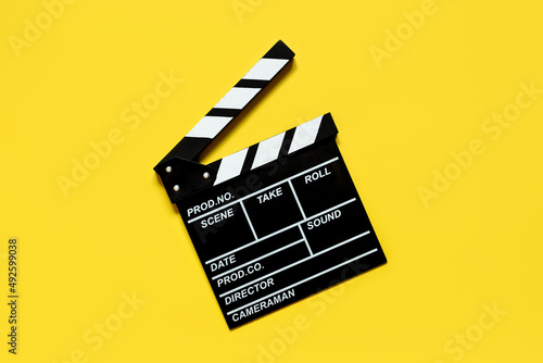 clapperboard for shooting video footage takes on a yellow background photo