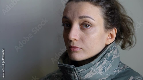 Indoor portrait of young girl wearing military uniform, mandatory conscription in Ukraine, Russian invasion, war concepts
