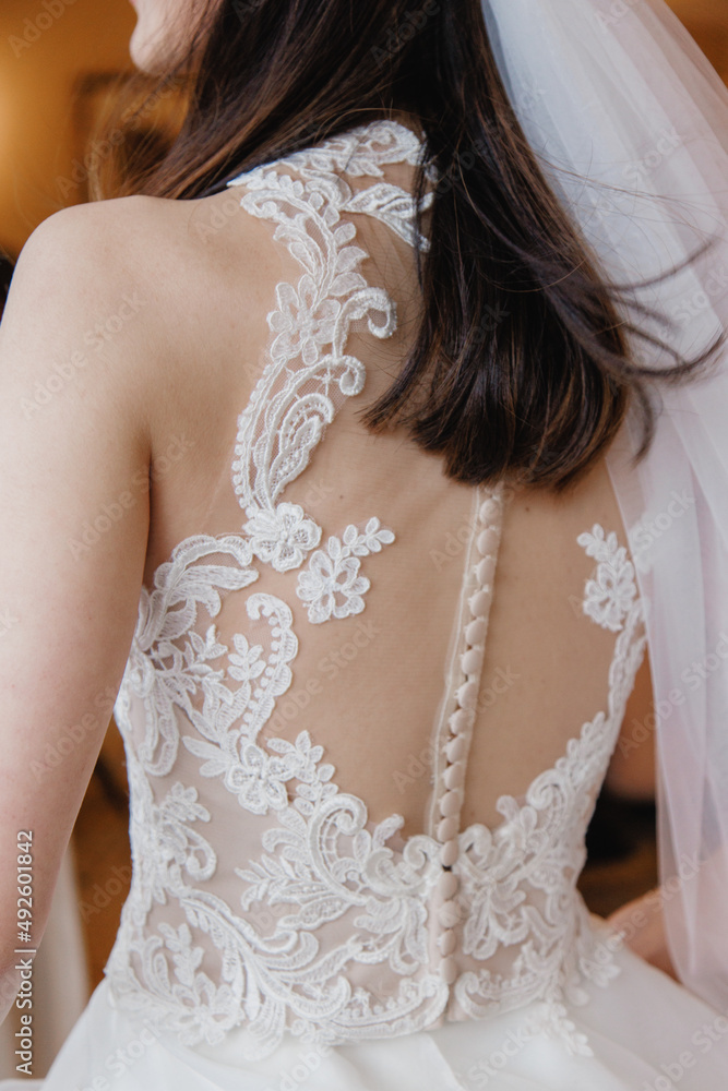 Cropped photo Bridal dress with naked back Close up Bride in a white lace dress with open back and shoulders Back view 