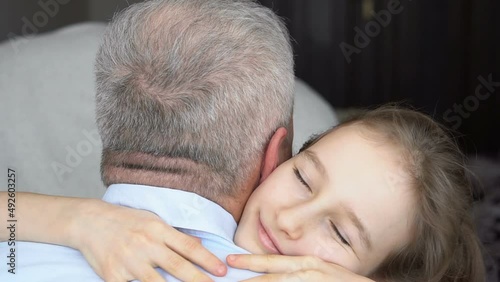 Family portrait of mature father and little blonde daughter hugging at home while celebrating father's day
