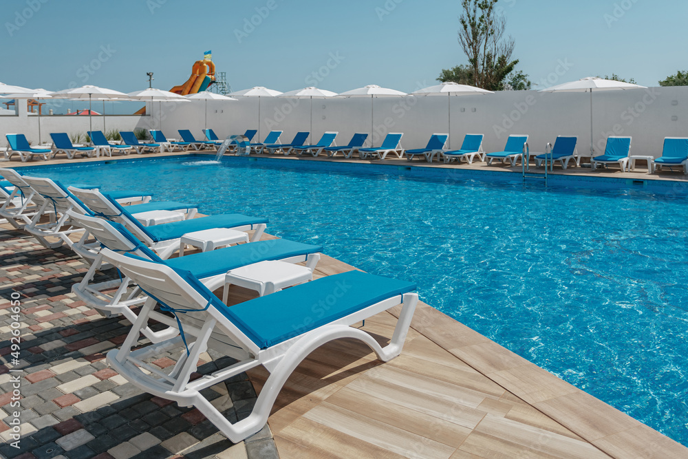 view of the pool with blue water and sun loungers