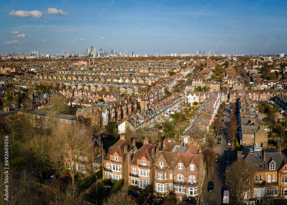 Aerial view of city of London skyline with terraced house rooftops of south west London in foreground 