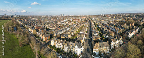Panoramic aerial view of city of London skyline with terraced house rooftops of south west London in foreground 