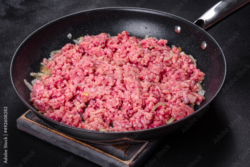 Fresh raw beef mince with onions in a pan Fresh raw beef mince with onions in a pan