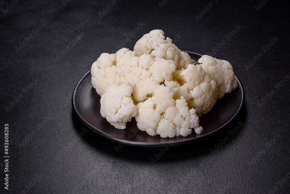 Beautiful swing of fresh white cauliflower on a dark concrete background Beautiful swing of fresh white cauliflower on a dark concrete background